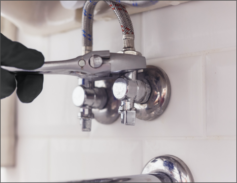 Plumber adjusting an angle valve under a basin